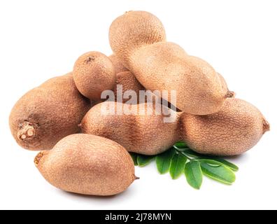 Cialde di frutta e foglie mature di tamarindo isolate su sfondo bianco. Foto Stock