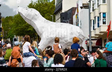 Brighton UK 7th May 2022 - Un orso polare gigante è trasportato attraverso le strade mentre migliaia di allievi, il personale ed i genitori prendono parte alla parata dei bambini di Brighton che è l'inizio tradizionale al festival di Brighton con il tema di quest'anno che è ricostruzione & speranza : Credit Simon Dack / Alamy Live News Foto Stock