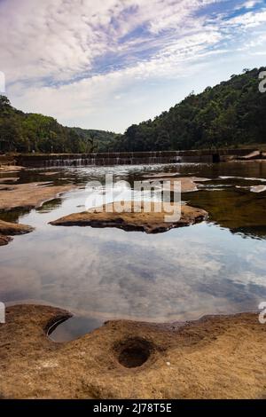 riverbed buco in pietra con acqua e circondato da foreste verdi da angolo piatto Foto Stock
