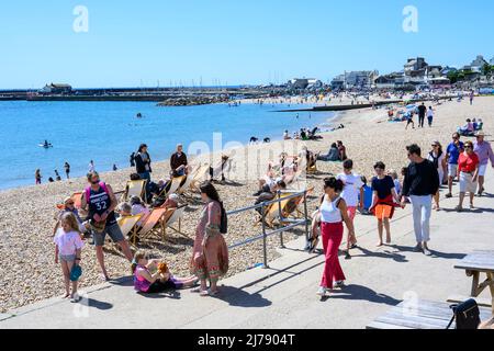 Lyme Regis, Dorset, Regno Unito. 7th maggio 2022. UK Meteo: Le folle si affollano alla spiaggia presso la stazione balneare di Lyme Regis per assorbire il sole caldo e cielo blu chiaro come l'onda di calore maggio inizia su ciò che è impostato per essere il giorno più caldo dell'anno finora. Credit: Celia McMahon/Alamy Live News. Foto Stock