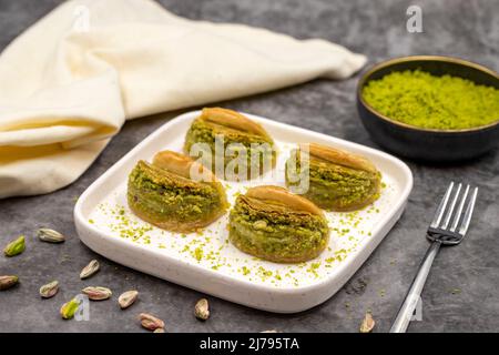 Pistacchio baklava. Baklava con pistacchio su sfondo scuro. Prelibatezze della cucina mediterranea. Primo piano. Nome locale dilber dudagi baklava Foto Stock