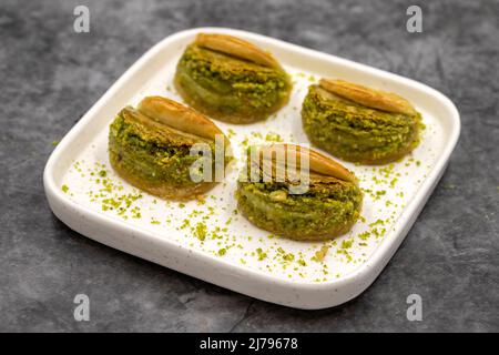 Pistacchio baklava. Baklava con pistacchio su sfondo scuro. Prelibatezze della cucina mediterranea. Primo piano. Nome locale dilber dudagi baklava Foto Stock