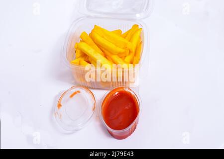 French Fries con Ketchup in lattine aplastica isolate su sfondo bianco Foto Stock