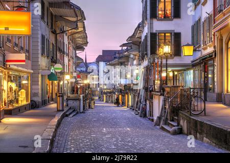 Tramonto lungo la storica Obere Hauptstrasse (strada) nel centro storico di Thun, Canton Berna, Svizzera. La strada commerciale corre parallela alla AA Foto Stock