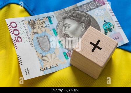 Banconota da 500+ cinquecento zloty con un simbolo più sullo sfondo della bandiera Ucraina, concetto di programma sociale polacco per le famiglie che sostengono Foto Stock