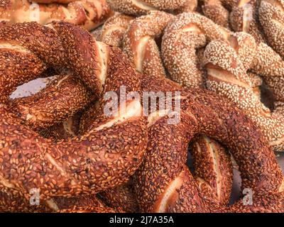 Un mucchio di deliziosi bagel turchi come sfondo. Fast food tradizionale noto come "simit" in Turchia Foto Stock