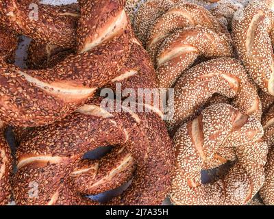 Un mucchio di deliziosi bagel turchi come sfondo. Fast food tradizionale noto come "simit" in Turchia Foto Stock