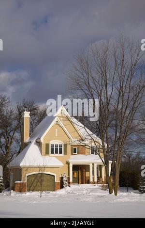 Moderno rosso sfumato mattone e beige legno asse rivestito due piani cottage casa stile paese in inverno. Foto Stock