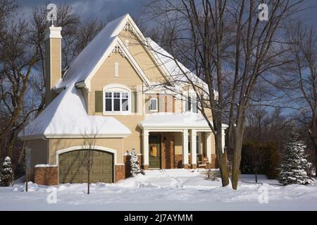 Moderno rosso sfumato mattone e beige legno asse rivestito due piani cottage casa stile paese in inverno. Foto Stock