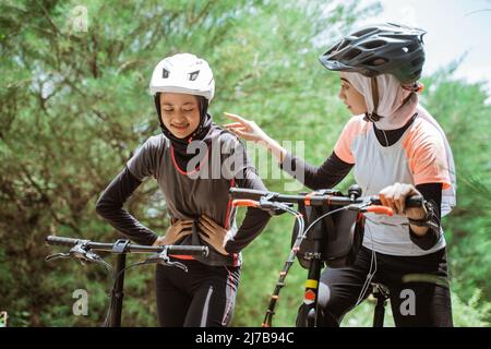 una donna ha un mal di stomaco mentre in bicicletta con gli amici Foto Stock
