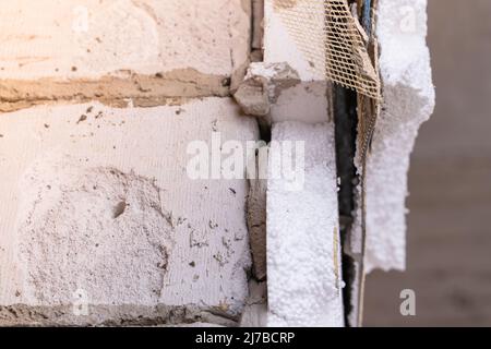 Smantellato isolamento in polistirene e rivestimento della facciata di una casa privata. Rimodellare l'esterno della casa Foto Stock