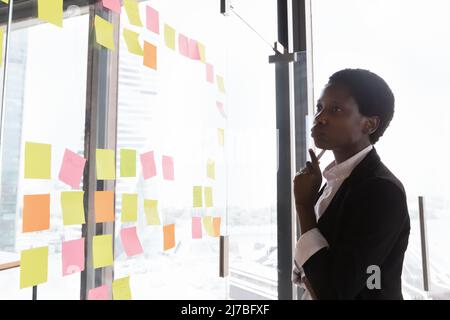 Seria e premurosa imprenditrice afroamericana che pensa al progetto Foto Stock