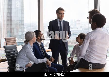 Leader del team aziendale positivo e fiducioso che motiva diversi dipendenti Foto Stock