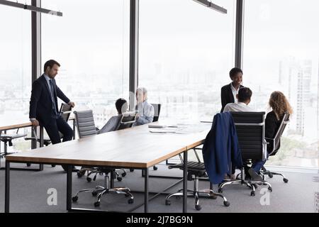 Due diversi team aziendali che si riuniscono separatamente in un ufficio moderno Foto Stock