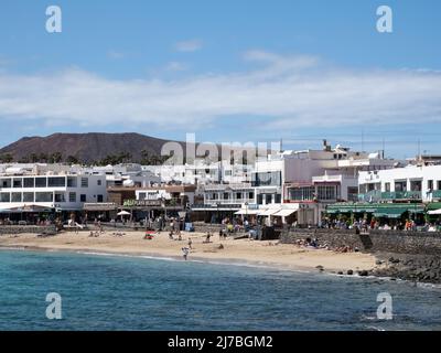 Playa Blanca, Spagna; marzo 26th 2022: Turisti che prendono il sole sulla spiaggia di Playa Blanca, Lanzarote. Destinazione di vacanza nelle Isole Canarie Foto Stock