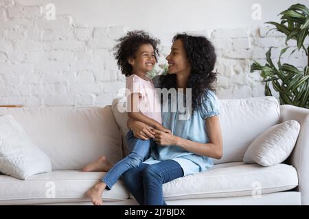 Felice mamma millenaria nera che tiene adorabile figlia gioiosa piccola Foto Stock