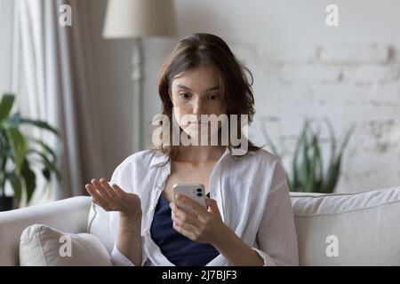 Scioccato cellulare utente ragazza fissando lo schermo, guardando lo smartphone Foto Stock