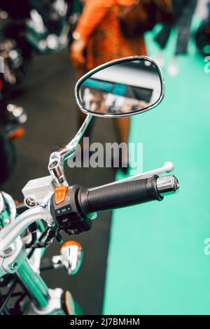 Particolare del manubrio e specchio di una moto personalizzata con riflessi Foto Stock