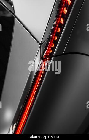 struttura in metallo opaco ultramoderno con forme curve e una plastica rossa con luce da dietro con un'atmosfera futuristica Foto Stock