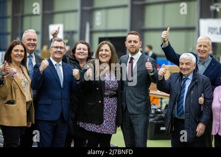 Gary Middleton (al centro) del DUP con sua moglie Julie Middleton (quinta a sinistra), il leader del partito Sir Jeffrey Donaldson (terza a sinistra), il collega del partito Gregory Campbell MP (destra) e i sostenitori della Meadowlands Arena di Magherafelt dopo essere stato dichiarato come MLA per Foyle, per le elezioni dell'Assemblea dell'Irlanda del Nord. Foto Stock