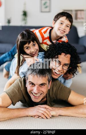 Scatto verticale di famiglia felice divertirsi insieme a casa. Foto Stock