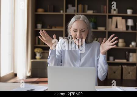 Felice eccitata donna d'affari senior sentirsi euforica, urlando per la gioia, Foto Stock