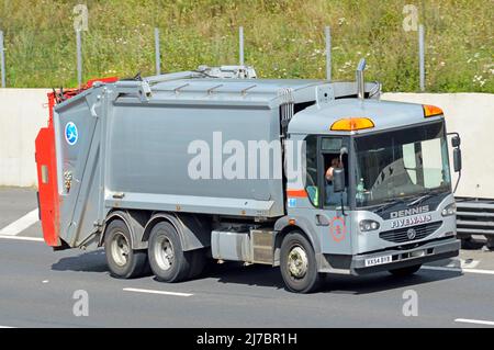 Conducente in pulito grigio non marcato Dennis hgv camion bidone per la raccolta di rifiuti domestici e aziendali rifiuti spazzatura guida lungo la strada autostradale del Regno Unito Foto Stock