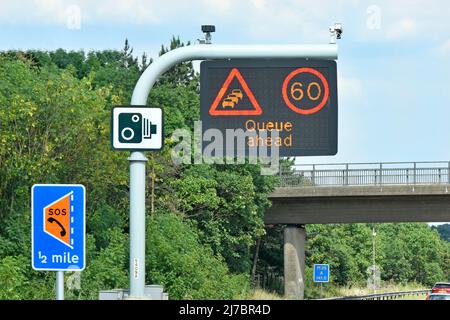 Cartello autostradale a pannello singolo M25 sopra la corsia un LIMITE di velocità variabile 60mph & Queue ahead message & Smart Lane layby Half Mile & standard camera signs UK Foto Stock