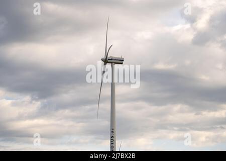 Turbina eolica della Vestas Wind Systems che ruota nel cielo. Vento sta girando le pale del generatore. Energia pulita da fonti rinnovabili. Foto Stock