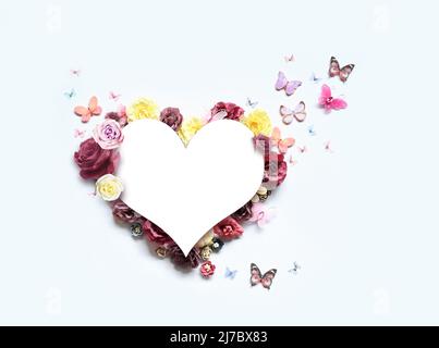 Buon giorno di madri e di San Valentino. Bouquet di rose colorate assortite a forma di cuore e farfalla su sfondo bianco. Foto Stock