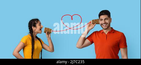 Messaggio di San Valentino. Romantica coppia araba comunicando attraverso carta tazza telefono Foto Stock