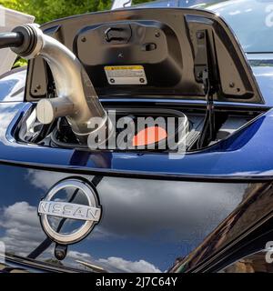 Nissan Leaf collegato a una stazione di ricarica Foto Stock