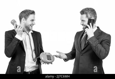 I professionisti felici di affari usano il telefono classico e il telefono delle cellule isolato su bianco, comunicazione Foto Stock