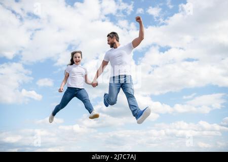 felice padre e figlia saltano in cielo Foto Stock