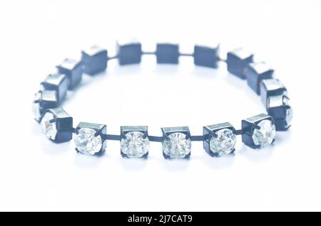 finto braccialetto diamantato con corda nera su sfondo bianco Foto Stock