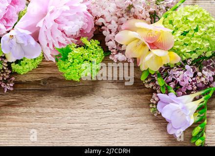 Lilaci, peonie e rosa verde di guelder (viburnum opulus) su sfondo di legno, spazio copia. Foto Stock