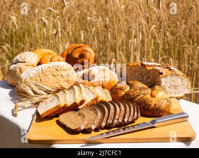 lotto di pane, grano, segale aromatizzato, sulla tavola all'esterno del campo Foto Stock