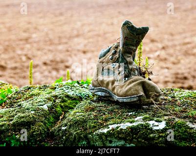 Un vecchio scarpone da trekking scartato Foto Stock