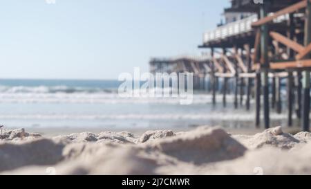 Sotto il molo in legno Crystal su pali, spiaggia oceano onde d'acqua, California USA. Vacanze estive sulla spiaggia di Mission, sulla riva di San Diego. Sotto il lungomare sulla costa del mare. Cinematografia senza giunture. Foto Stock