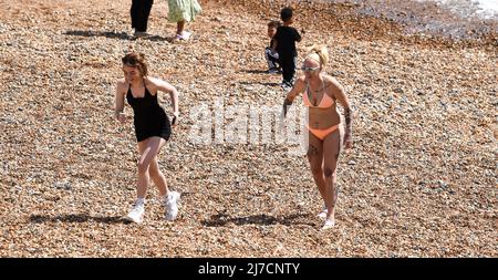 Brighton UK 8th May 2022 - i visitatori godono di una calda giornata di sole sulla spiaggia di Brighton e sul lungomare, come si prevede che le temperature raggiungano oltre 20 gradi in alcune parti del Regno Unito: Credit Simon Dack / Alamy Live News Foto Stock