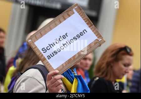 08 maggio 2022, Baviera, Monaco di Baviera: Un partecipante a un raduno contro la guerra in Ucraina detiene un cartello con la scritta 'Esclude Schröder' durante una marcia attraverso il centro della città. Foto: Karl-Josef Hildenbrand/dpa Foto Stock