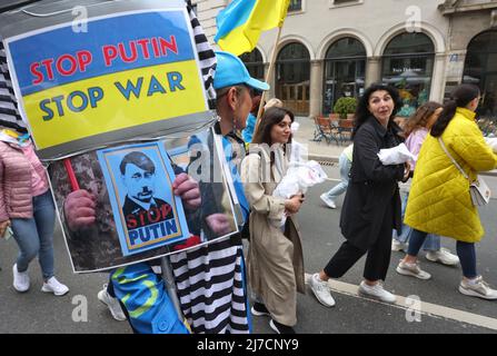 08 maggio 2022, Baviera, Monaco di Baviera: Un partecipante a un raduno contro la guerra in Ucraina ha un segno che legge 'ARRESTARE PUTIN FERMARE LA GUERRA' durante una marcia attraverso il centro della città. Foto: Karl-Josef Hildenbrand/dpa Foto Stock