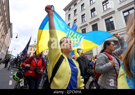 08 maggio 2022, Baviera, Monaco: I partecipanti ad un raduno contro la guerra in Ucraina marciano attraverso il centro della città con bandiere ucraine in una processione dimostrativa. Foto: Karl-Josef Hildenbrand/dpa Foto Stock