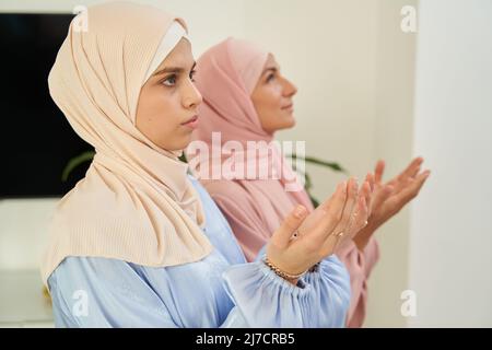 Le donne musulmane pregano insieme a casa Foto Stock