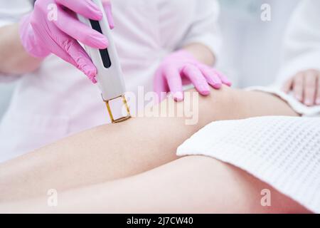 Estetista che effettua il trattamento di rimozione dei capelli del laser nel salone di bellezza Foto Stock