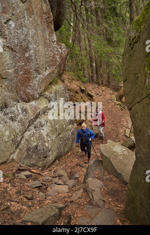 Due escursionisti che si muovono attraverso il passaggio tra due montagne Foto Stock