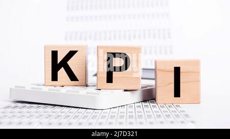 Indicatori chiave delle prestazioni. Lettere KPI a cubi, calcolatrici e documenti con statistiche. Valutazione del successo nel raggiungimento degli obiettivi aziendali. Pianificazione strategica. Foto di alta qualità Foto Stock