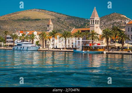 Splendida vista con yacht di lusso e vecchia nave nel porto turistico. Spettacolare lungomare con palme e caffè di strada, Trogir, Dalmazia, C. Foto Stock