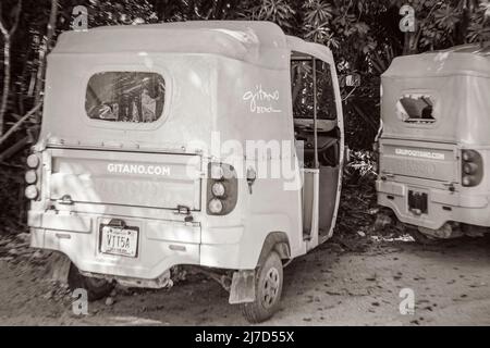 Tulum Messico 02. Febbraio 2022 Vecchio quadro in bianco e nero di guida attraverso la strada colorata tipica e paesaggio urbano con tuk tuk auto traffico palma t Foto Stock