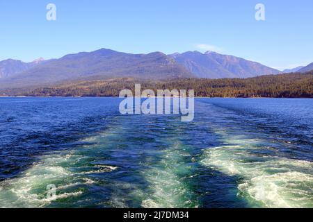 Un traghetto wake sul Lago Kootenay con le Purcell Mountains sullo sfondo tra Kootenay Bay e Balfour British Columbia, Canada. Foto Stock